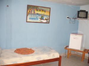 Pousada Chalé Suiço في بارنايبا: غرفة بسرير وصورة على الحائط
