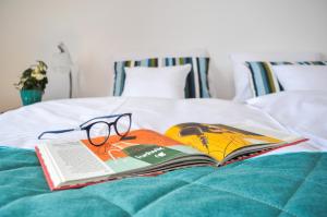 a book and glasses sitting on top of a bed at Zajazd Dabie in Dąbie