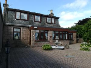 a brick house with a fountain in front of it at Celicall in Ballater