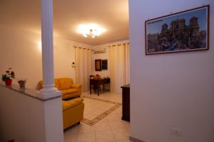 sala de estar con sofá amarillo y mesa en Noto Bedda Bed&Breakfast, en Noto