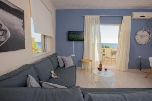 a blue living room with a couch and a table at Golden Sun Apartments in Kokkinos Pirgos
