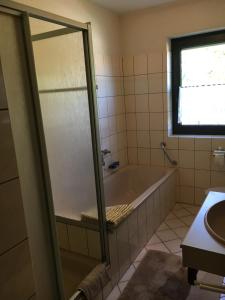a bathroom with a bath tub and a window at VormHolte in Radevormwald
