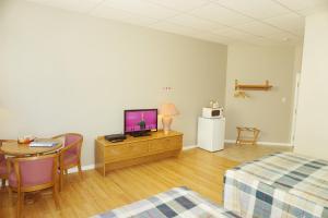 a room with a bed and a table and a television at Motel Casino in Gatineau