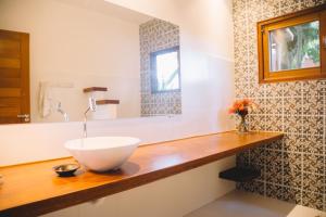 un bagno con lavandino bianco su un bancone in legno di Casa Crescente a Trancoso