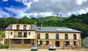 a large building with cars parked in front of it at Hotel Rural Nova Ruta in Trabadelo