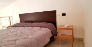 a bedroom with a bed and a table with a lamp at Mini Loft Porto Torres in Porto Torres