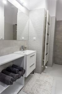a white bathroom with a sink and a mirror at Premium Apartment Centrum in Poprad
