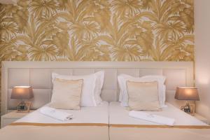 a bedroom with a bed with two pillows and a wallpaper at Splendido MB Apartments in Tivat