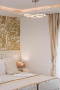 a bedroom with a bed and a chandelier at Splendido MB Apartments in Tivat