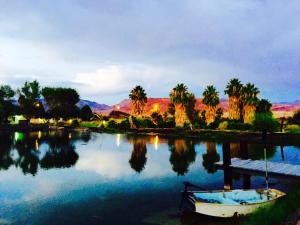 a boat sitting on the water with palm trees at Shoshone RV Park in Shoshone