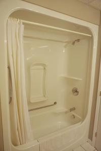 a white shower with a shower curtain in a bathroom at Motel Casino in Gatineau