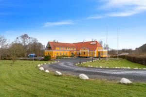 a large yellow house on a winding road at Krebshuset / Kelz0rdk in Sorø