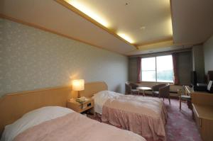 سرير أو أسرّة في غرفة في New Akan Hotel