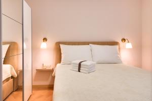 een slaapkamer met een wit bed met 2 kussens bij Apartments Dalmatino in Vodice