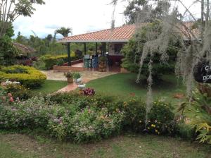 a garden with a house with a gazebo at Villa Liliana Lodge Mesa de los Santos in Los Santos