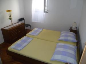 a small bedroom with two beds and a dresser at Vesna Pag Potočnica in Borovići