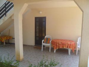 a patio with a table and chairs and a staircase at Vesna Pag Potočnica in Borovići