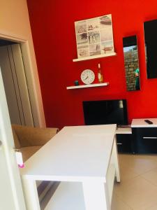 a red room with a white desk and a clock at Sunset House in Ksamil