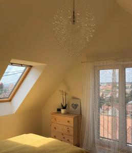 1 dormitorio con cama, ventana y lámpara de araña en Annabel Villa Eger en Eger