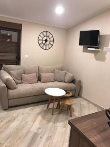 - un salon avec un canapé, une table et un réveil dans l'établissement Masanda Luxury Apartments, à Dobropoljana