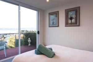 een slaapkamer met een bed en een groot raam bij 567 Sandy Bay in Hobart