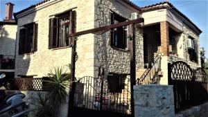 une maison en pierre avec une porte noire devant elle dans l'établissement Elisw, à Afytos