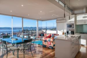 een keuken en een woonkamer met een tafel en stoelen bij 567 Sandy Bay in Hobart