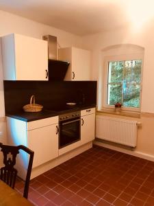 a kitchen with a stove and a window at Ferienheim Kuckuckswinkel in Schöna +12 photos