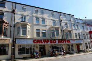 黑潭的住宿－Calypso hotel Blackpool，一座白色的大建筑,前面的人在步行