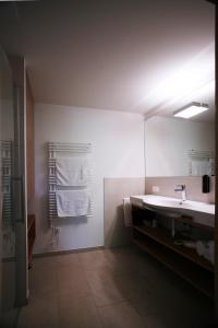 a bathroom with a sink and a mirror and towels at Apart-Faakersee in Drobollach am Faakersee