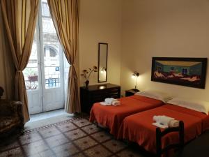 a bedroom with a bed with two towels on it at Aloi Rooms in Catania