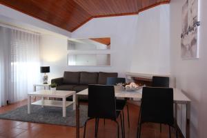 una sala de estar con una mesa y un sofá en Subvilla Beach Place, en Nazaré