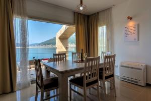 a dining room with a table and chairs and a window at Apartments Villa Adriatic in Tivat