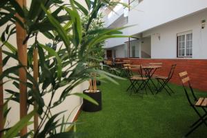 a room with tables and chairs and a plant at Subvilla Beach Place in Nazaré