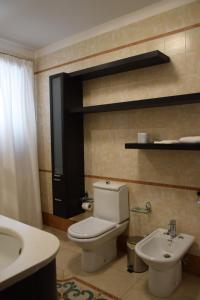 a bathroom with a white toilet and a sink at La Suite del Vulcano in Belpasso