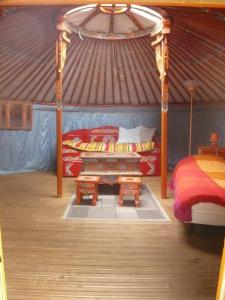um quarto com uma cama e uma mesa numa tenda em Le Village Insolite yourte et roulotte em Saint-Benoît-des-Ondes