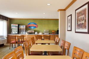 a restaurant with tables and chairs and a counter at Baymont by Wyndham Salina in Salina