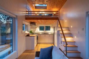 a tiny house with a staircase and a kitchen at Golden Bay Hideaway in Takaka