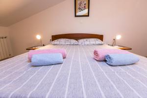 a bedroom with a bed with pink and blue pillows at Amela in Pula