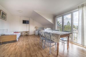 a room with a table and chairs and a bedroom at Arka Przystań in Jastrzębia Góra