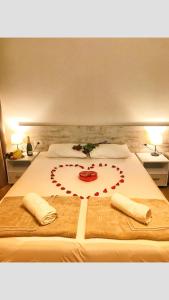 uma cama com um coração feito de rosas vermelhas em Apartments Sarić em Bar