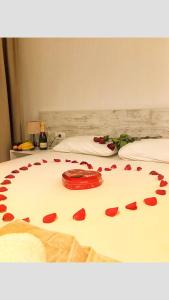 a bed with red rose petals on it at Apartments Sarić in Bar