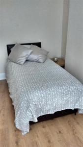 a bed with two pillows on it in a bedroom at Derwent Street Apartment 1 - 3 Bed Self Catering Apartment - Self Contained - 1 Double & 2 Single Rooms in Workington