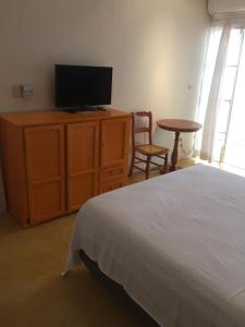 a bedroom with a bed and a tv and a table at Casa De La Luz - Guesthouse in Tlacotalpan