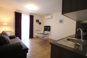 a kitchen and living room with a couch and a table at Apartments Supra Mare in Rabac