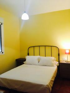 a bedroom with a bed with a yellow wall at Casa Alma in Almería