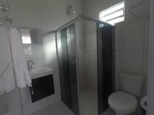 a bathroom with a shower and a toilet and a sink at Pousada e Chales Mambaí Inn in Mambaí +57 photos