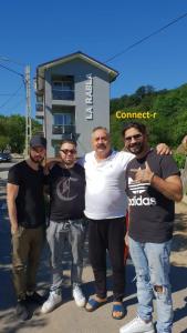 three men posing for a picture in front of a building at La Rabla in Dubova