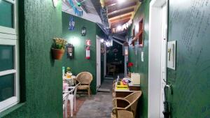 Cette chambre est dotée d'un mur vert, d'une table et de chaises. dans l'établissement Hospedagem Da Laranjeira Gramado, à Gramado