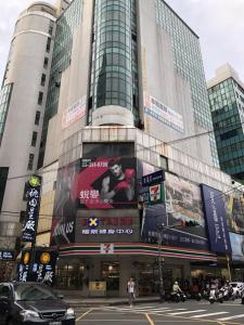 a building with a large sign on the side of it at Honest & Warm Hotel in Taoyuan